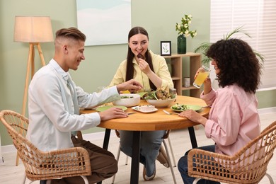 Friends having vegetarian meal at table in cafe