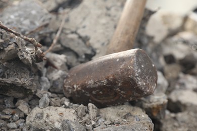 Photo of Sledgehammer on pile of broken stones outdoors, closeup