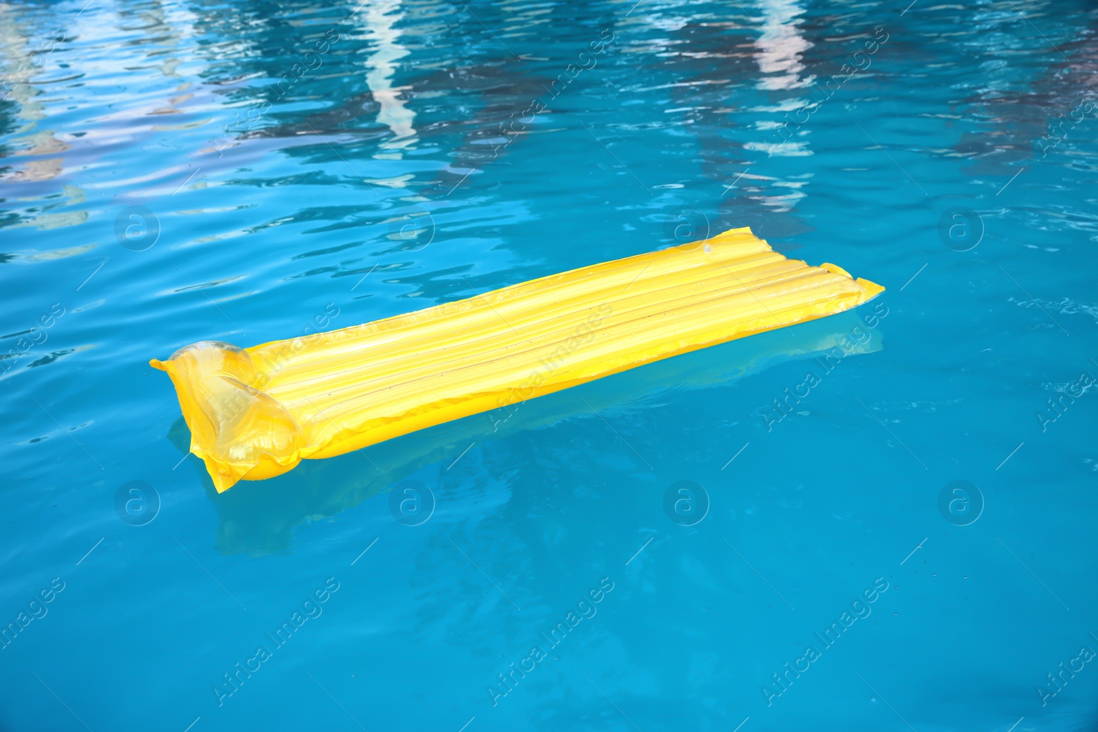 Photo of Inflatable mattress floating in swimming pool on sunny day