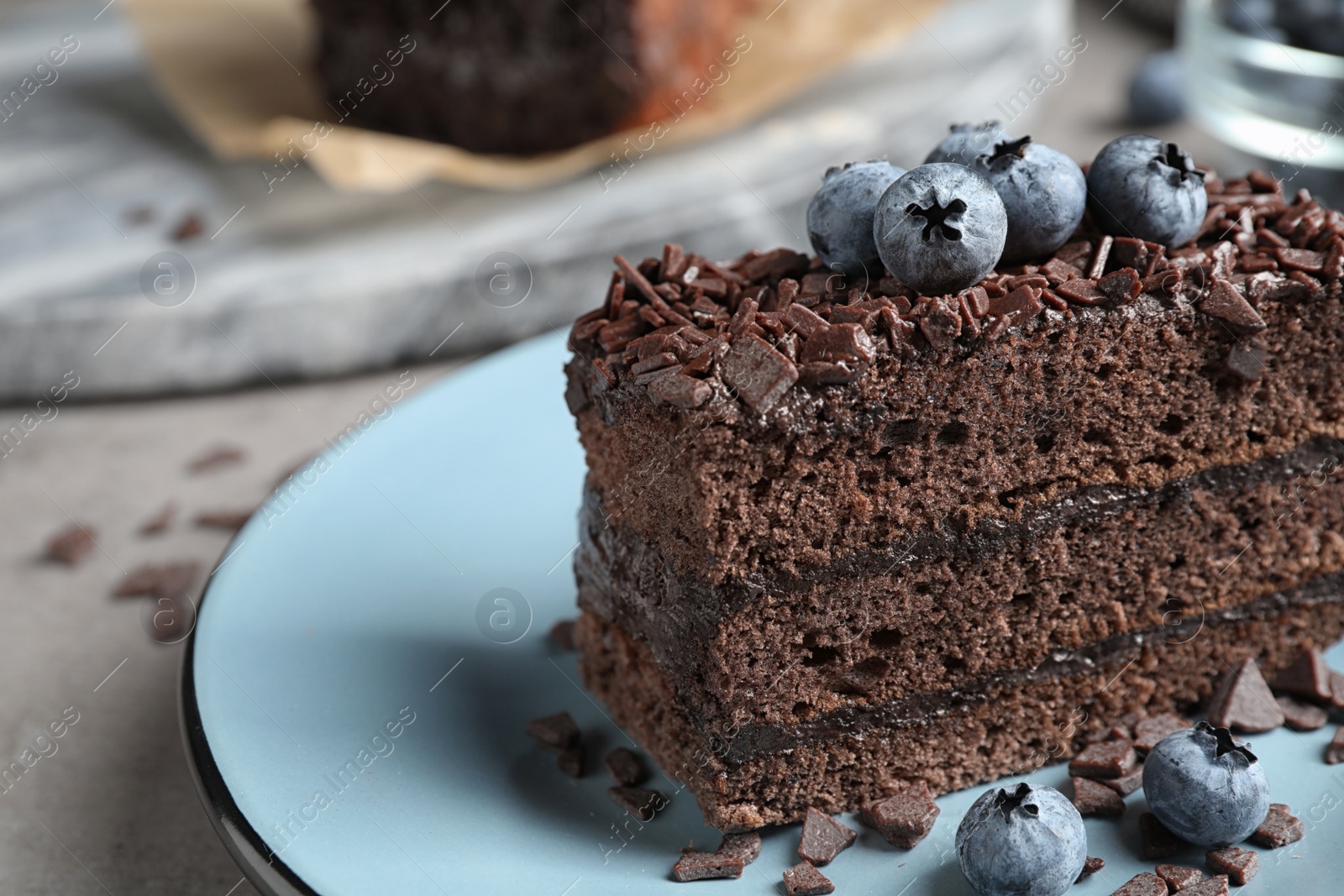 Photo of Delicious fresh chocolate cake with blueberries on table, closeup