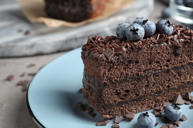 Delicious fresh chocolate cake with blueberries on table, closeup