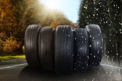 Image of Set of new winter and summer tires on asphalt road, collage 
