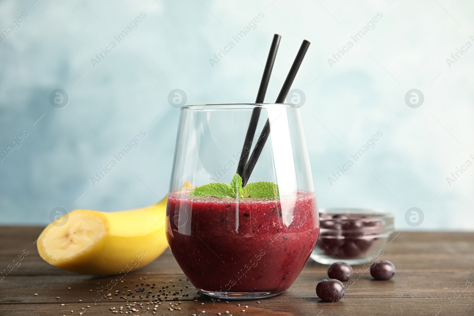 Photo of Glass with delicious acai smoothie on wooden table