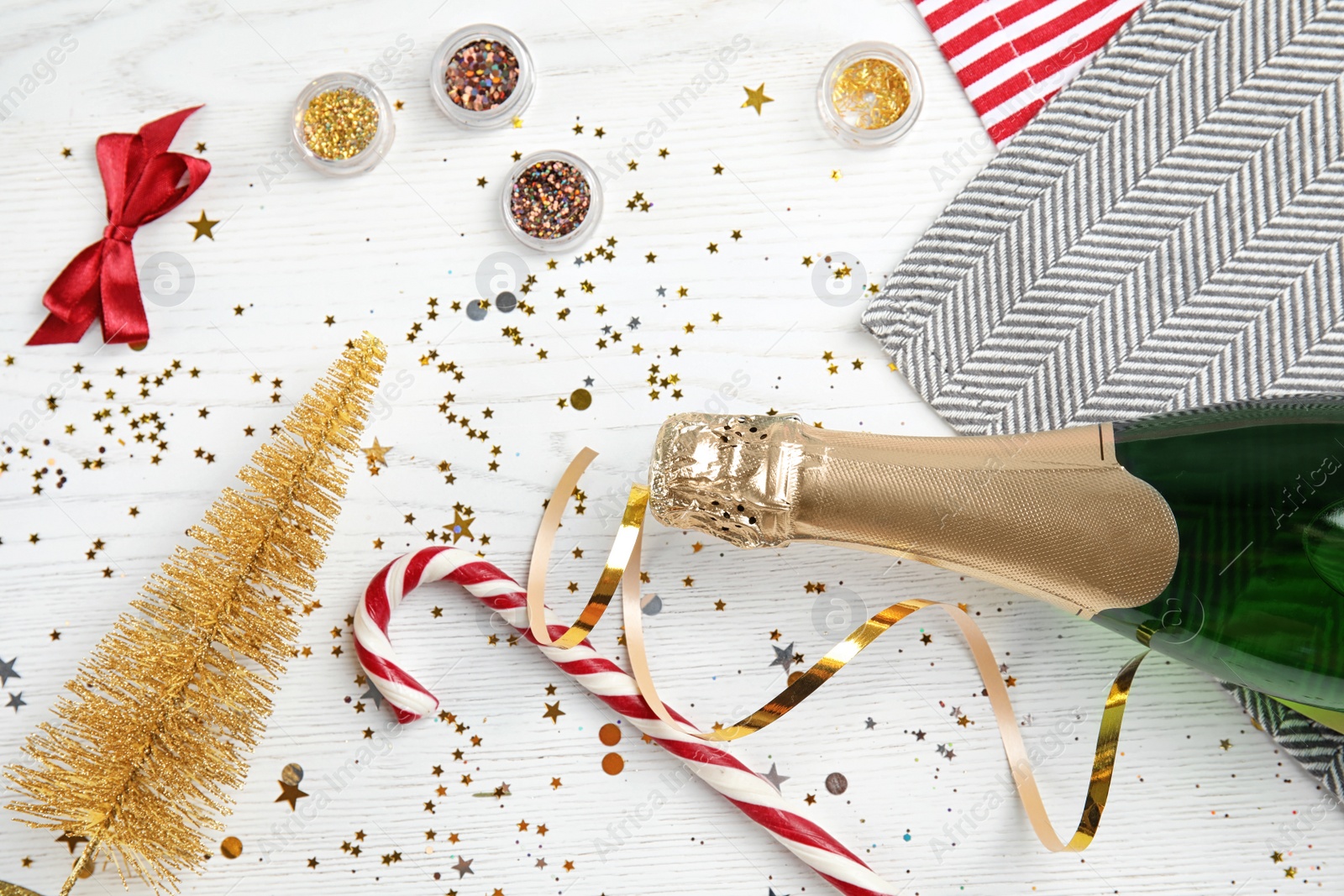 Photo of Christmas composition with bottle of champagne and decor on wooden background, top view