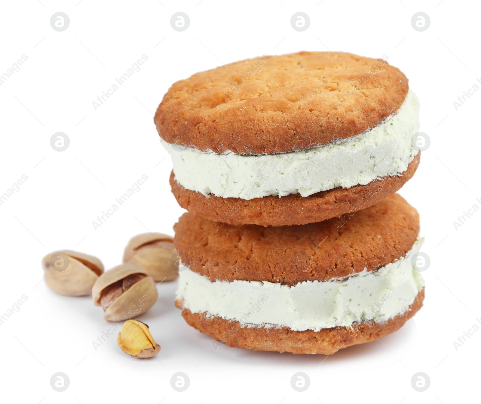 Photo of Sweet delicious ice cream cookie sandwiches and pistachios on white background