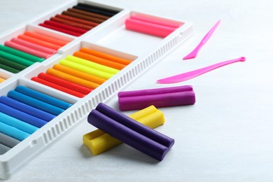 Colorful plasticine and tools on white table