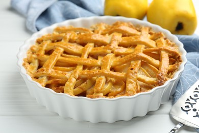 Photo of Tasty homemade quince pie on white wooden table, closeup