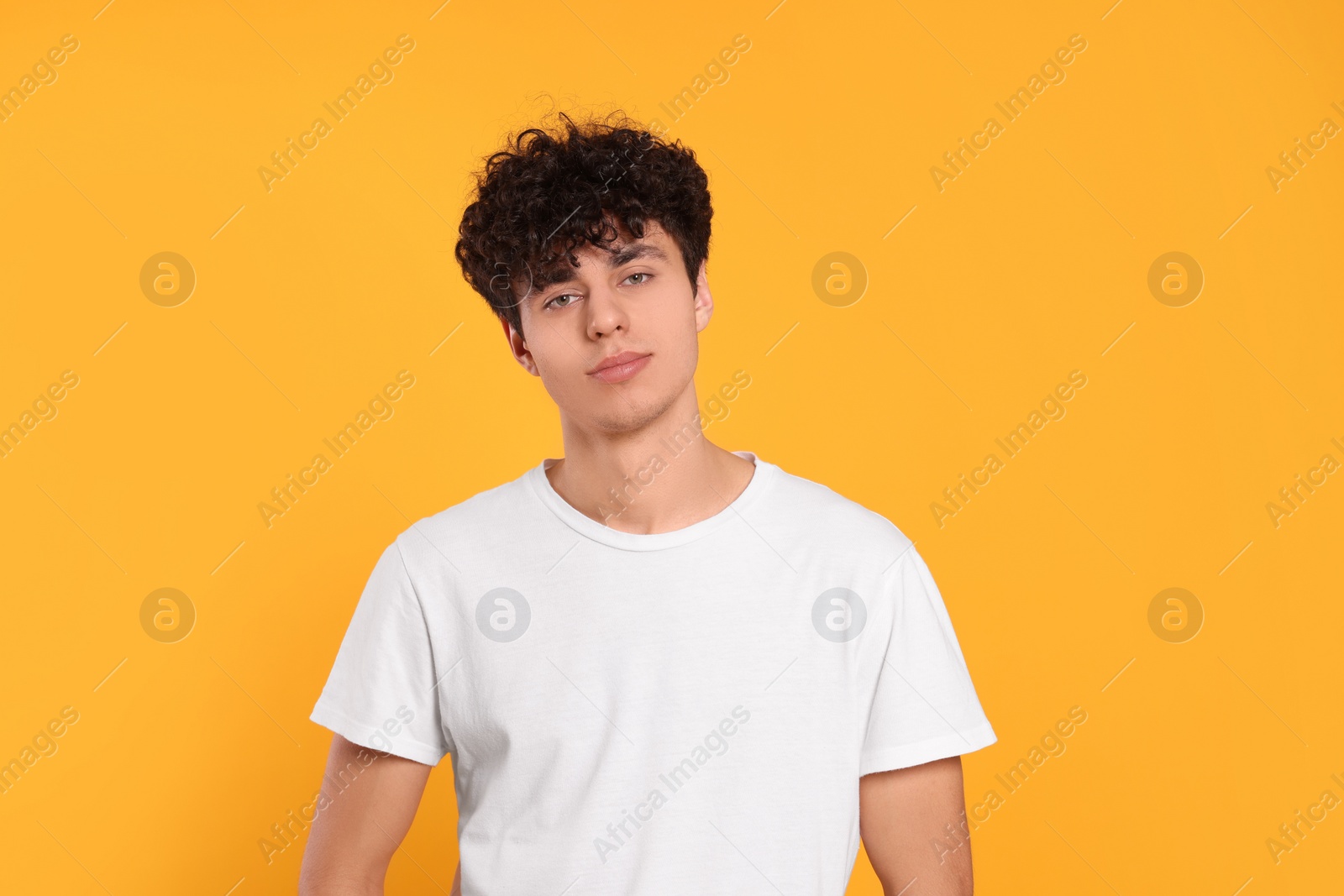 Photo of Portrait of handsome young man on orange background