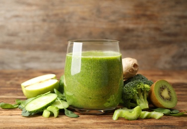 Photo of Green juice and fresh ingredients on wooden table
