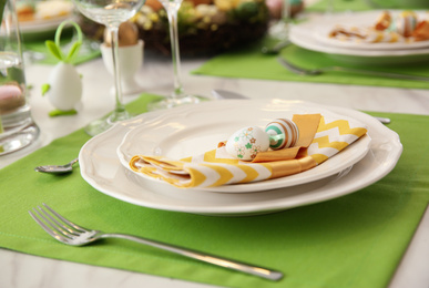 Photo of Festive Easter table setting with eggs, closeup