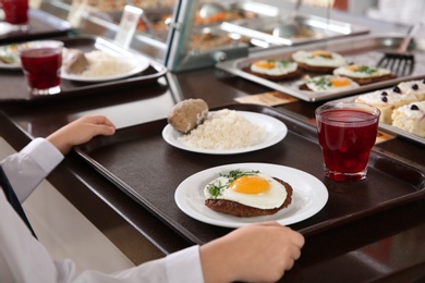 Photo of Girl near serving line with healthy food in school canteen, closeup