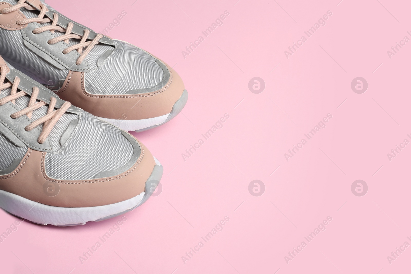 Photo of Pair of sports shoes on color background, closeup. Space for text