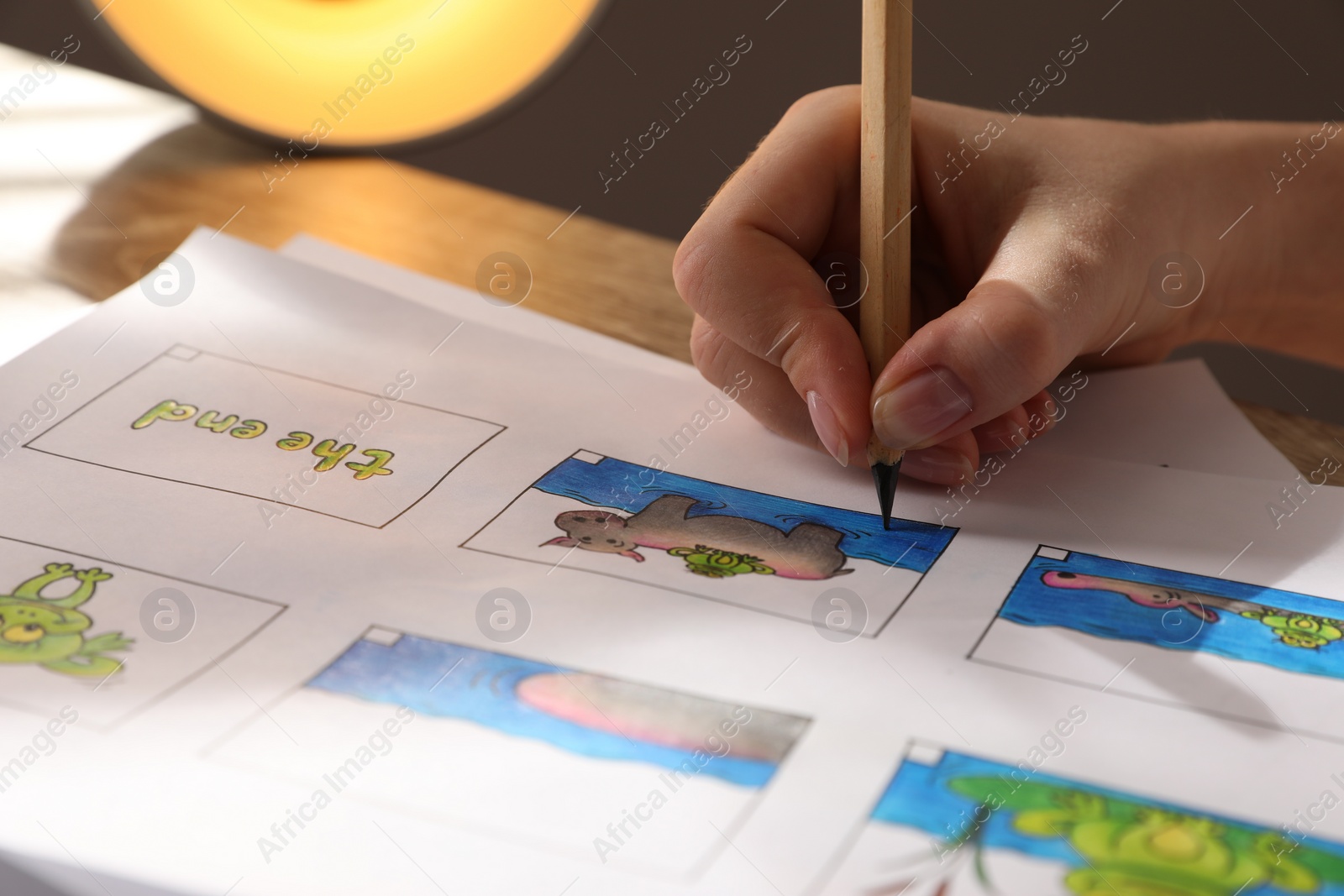 Photo of Woman drawing cartoon sketch in storyboard at workplace, closeup. Pre-production process