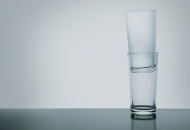 Photo of Stack of empty shooter glasses on white background