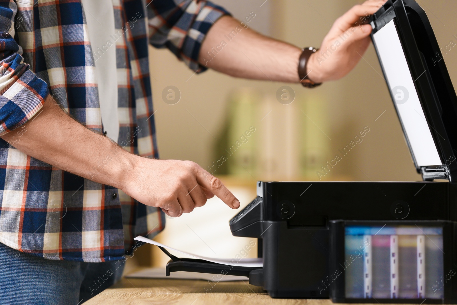 Photo of Man using modern multifunction printer in office, closeup