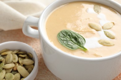 Photo of Healthy cream soup high in vegetable fats on color textured table, closeup