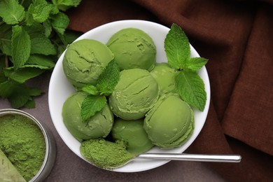 Photo of Tasty matcha ice cream and spoon with powder on brown table, flat lay