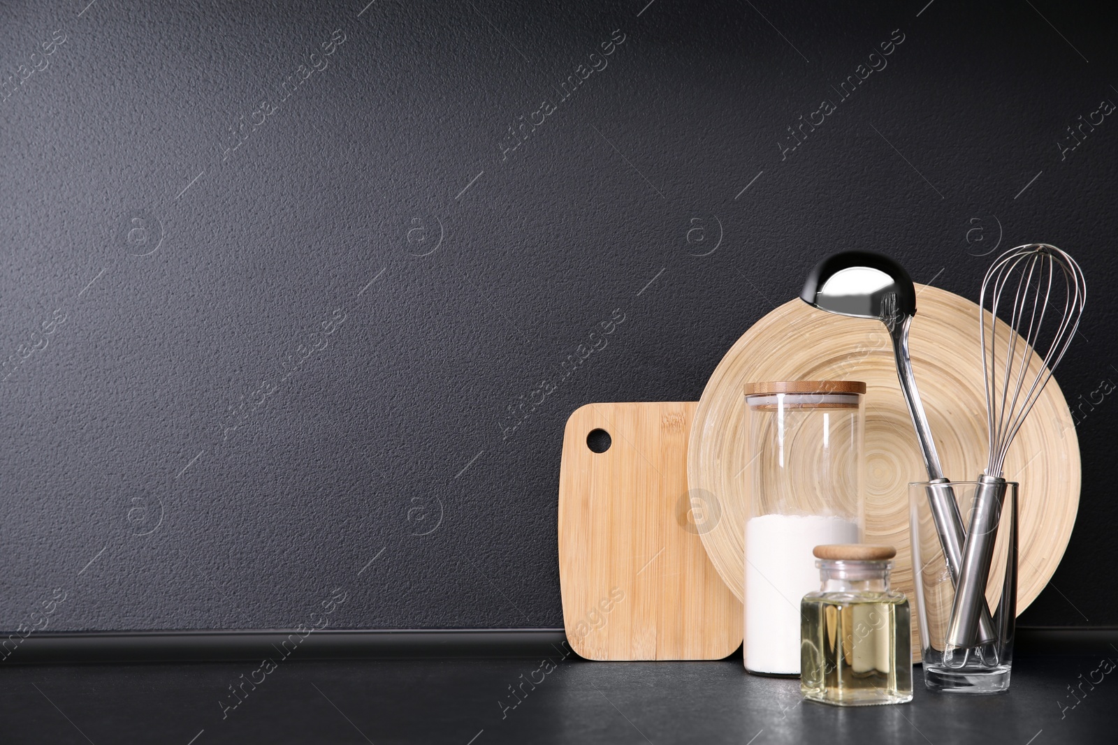 Photo of Composition with kitchenware on table against grey background. Space for text