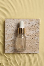 Photo of Bottlecosmetic serum and water on beige background, top view