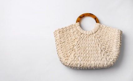 Photo of Stylish straw bag on white background, top view. Summer accessory