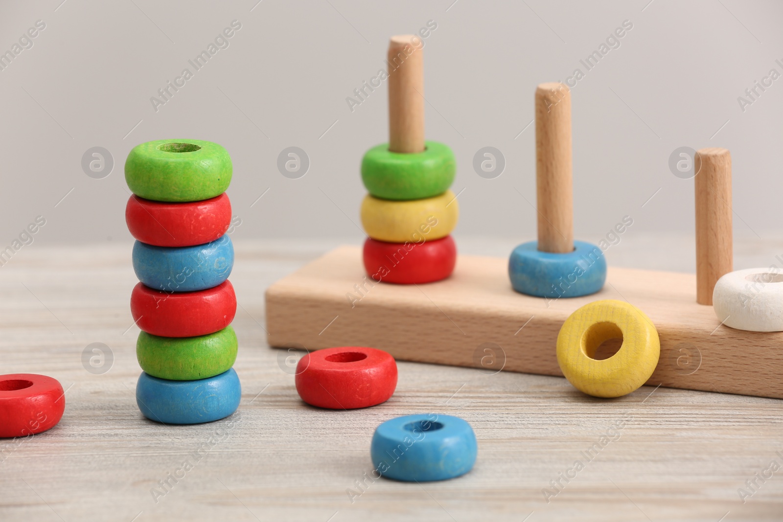 Photo of Educational toy for motor skills development. Stacking and counting game pieces on light wooden table