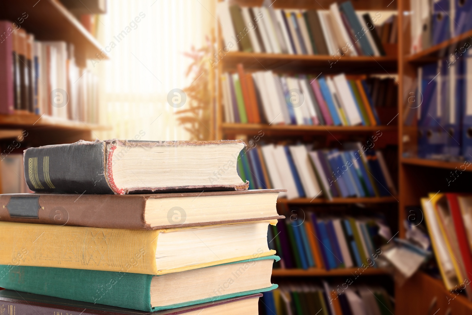 Image of Many stacked hardcover books in library, space for text