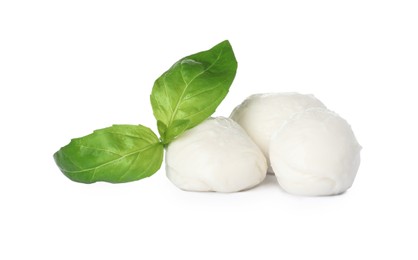 Delicious mozzarella cheese balls and basil on white background