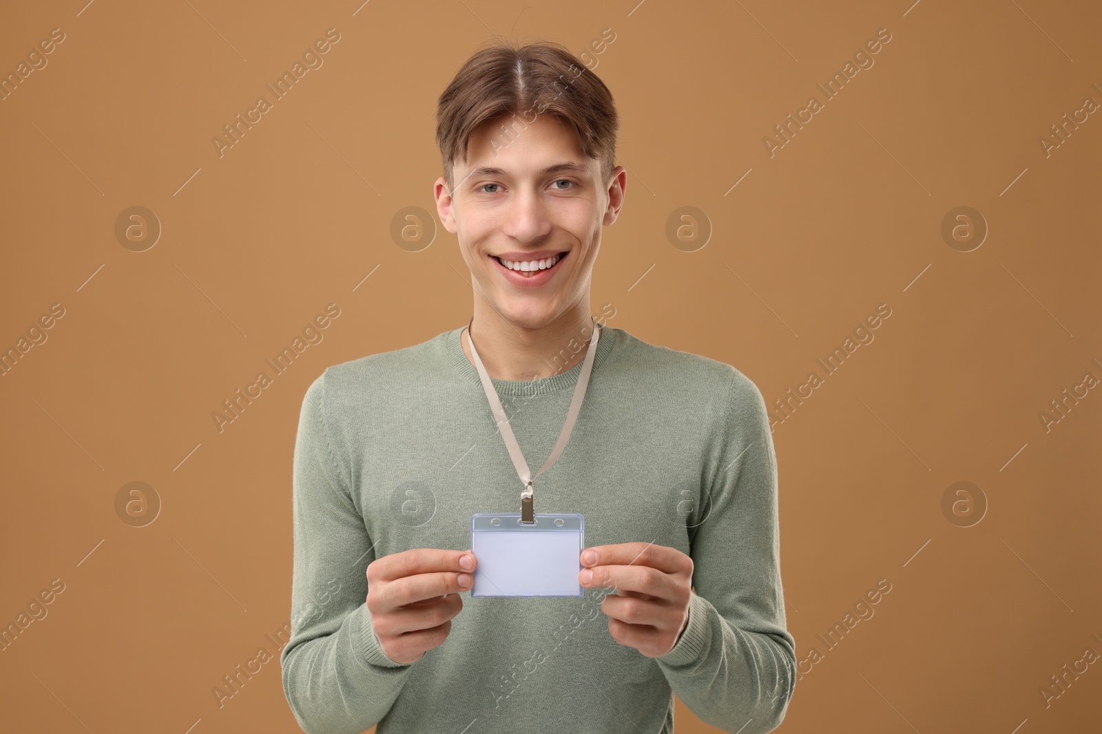 Photo of Happy man with blank badge on light brown background