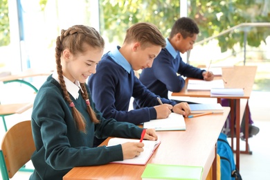 Photo of Teenage students in classroom. Stylish school uniform