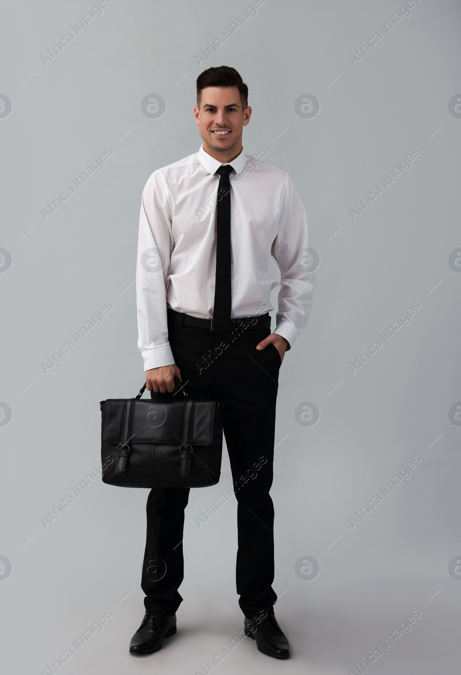 Photo of Businessman with stylish leather briefcase on light background