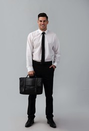 Businessman with stylish leather briefcase on light background