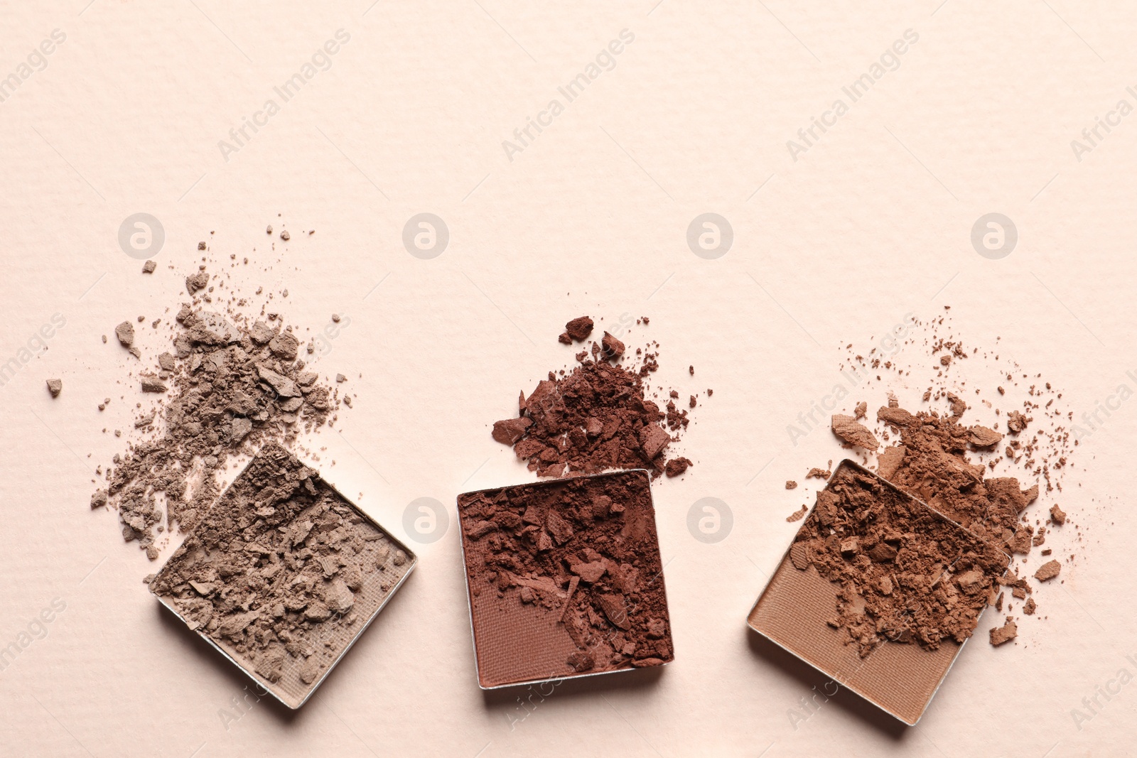 Photo of Different crushed eye shadows on beige background, flat lay. Space for text