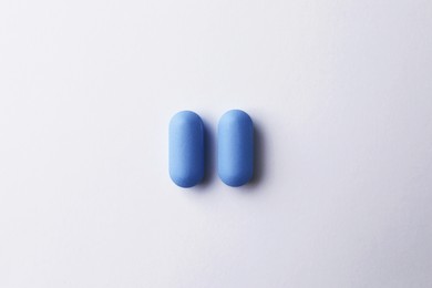 Pills on white background, top view. Potency problem
