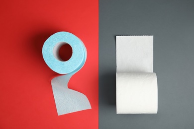 Flat lay composition with toilet paper rolls on color background