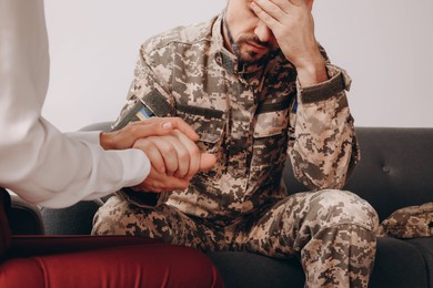 Psychologist supporting military officer in office, closeup