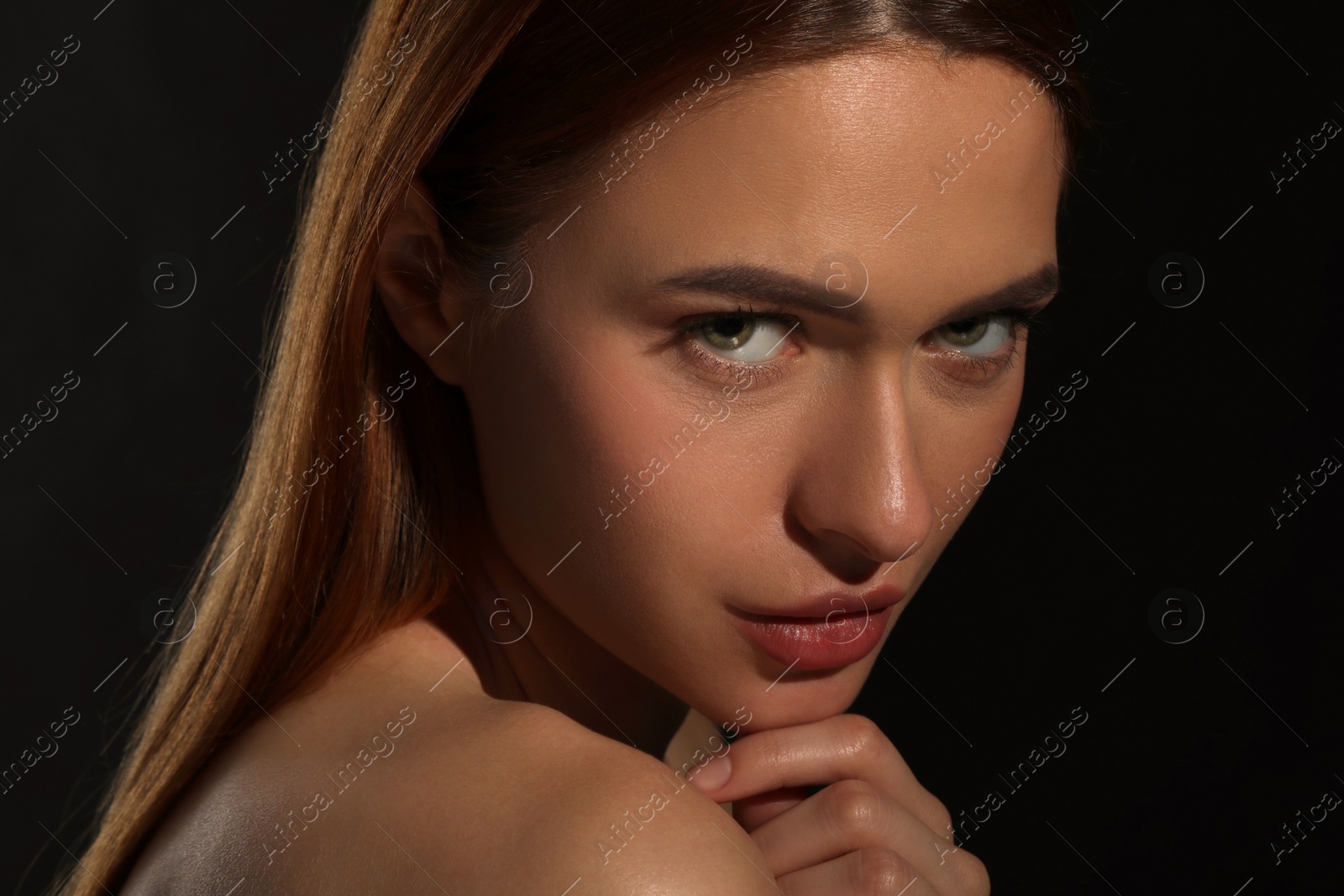 Photo of Evil eye. Young woman with scary eyes on black background