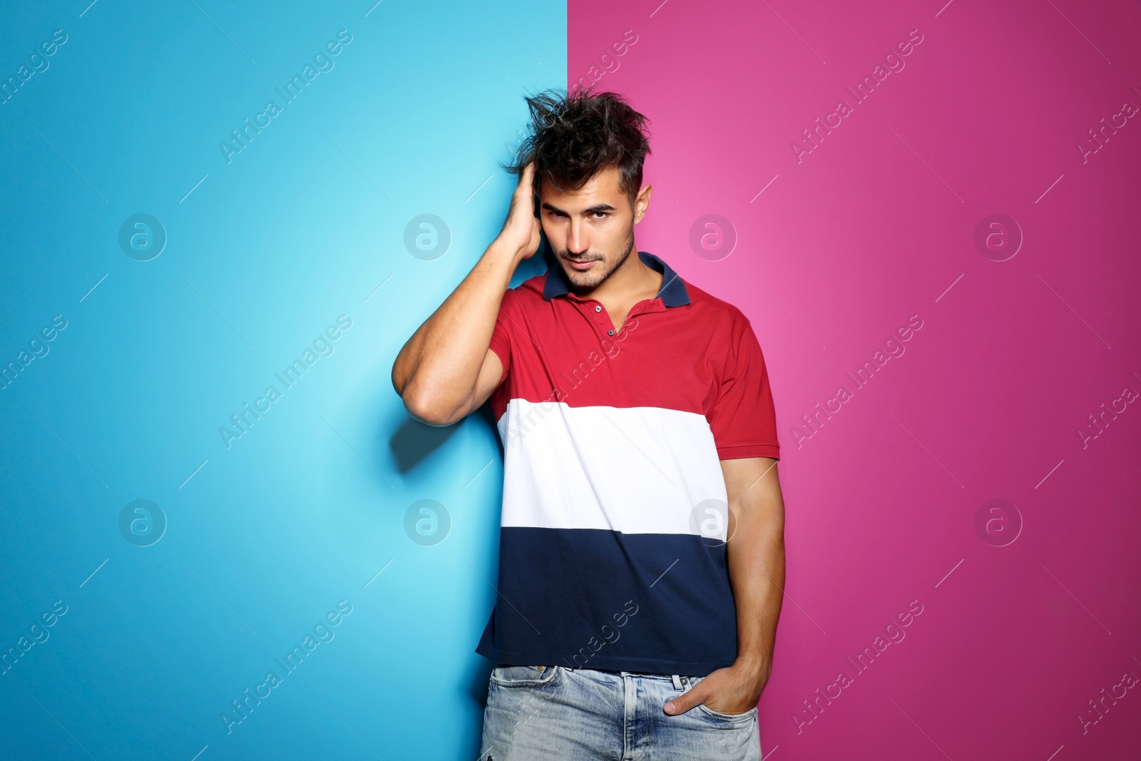 Photo of Young man with trendy hairstyle posing on color background