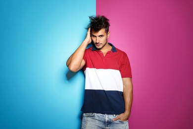 Photo of Young man with trendy hairstyle posing on color background