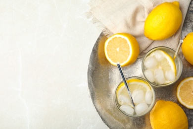 Photo of Soda water with lemon slices and ice cubes on white table, top view. Space for text