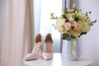 Photo of Wedding bouquet, shoes and beige dress indoors