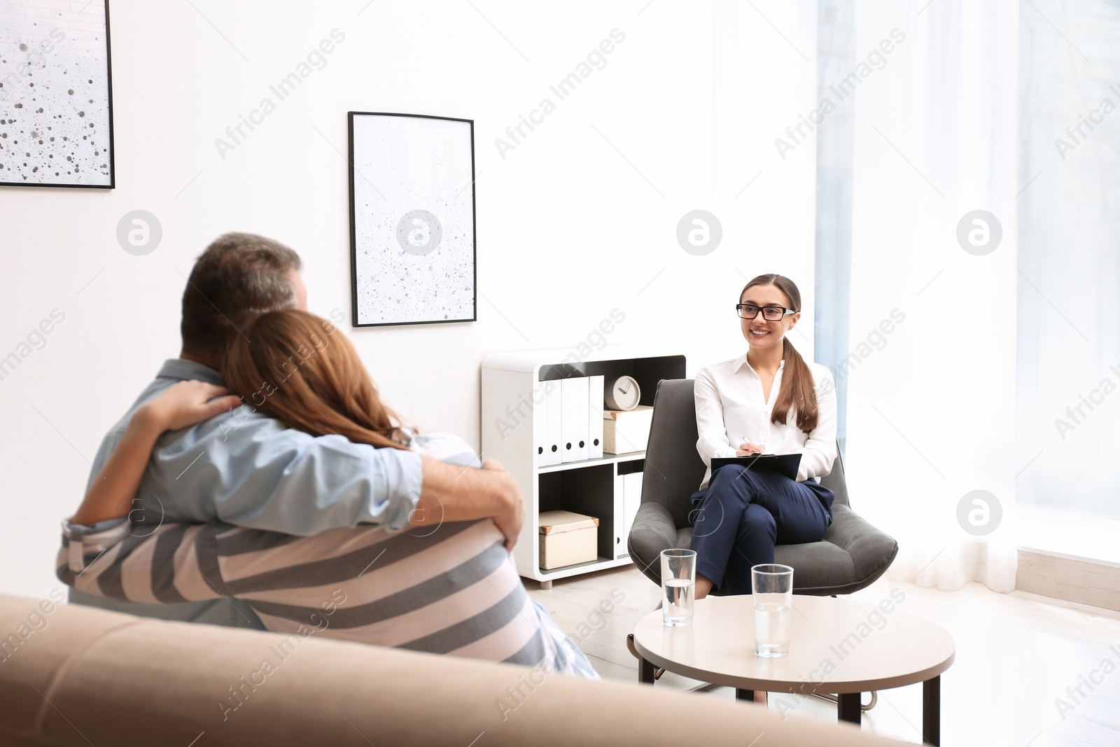 Photo of Psychotherapist and happy couple having meeting in office. Family counselling