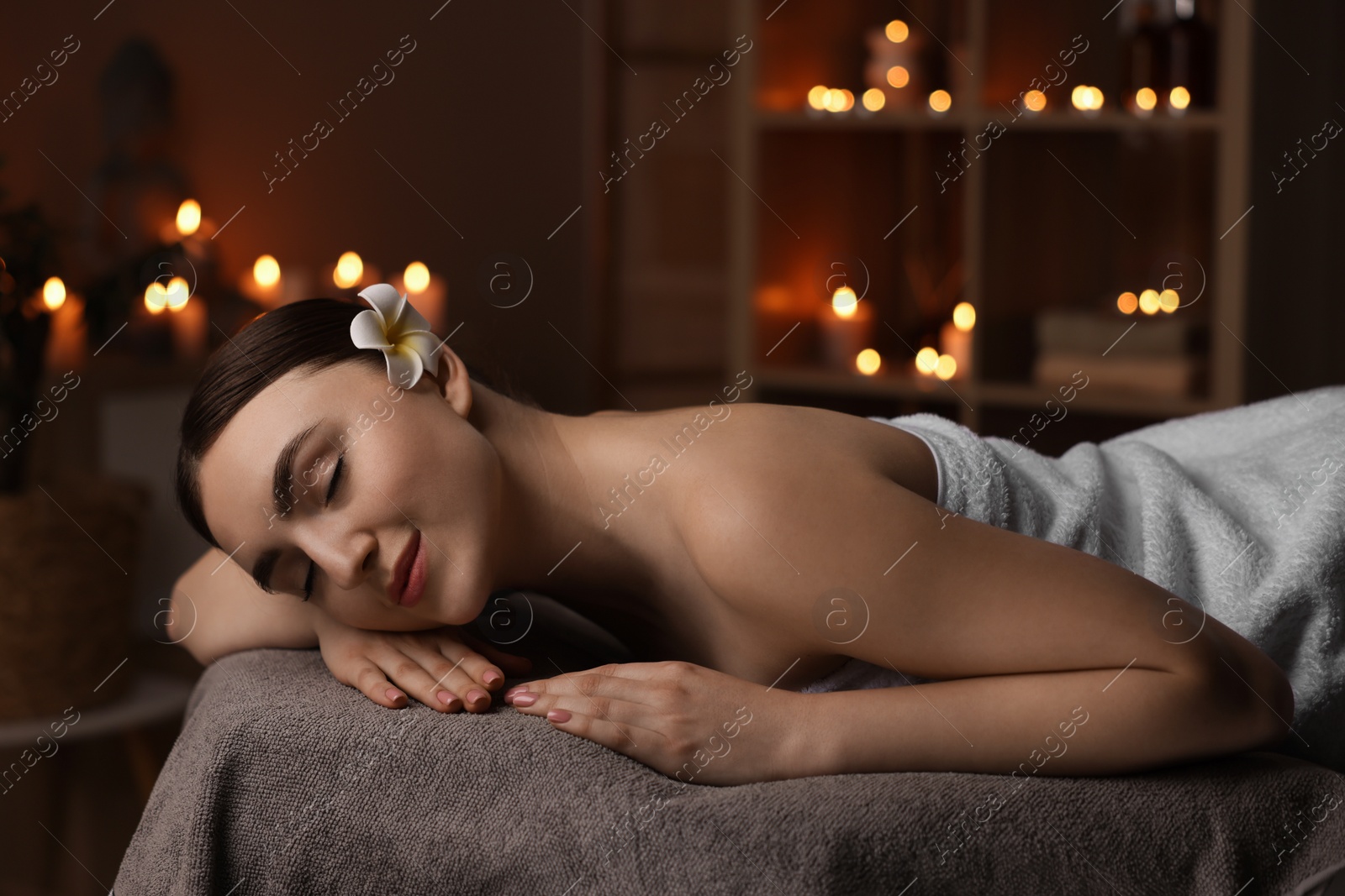 Photo of Spa therapy. Beautiful young woman lying on massage table in salon