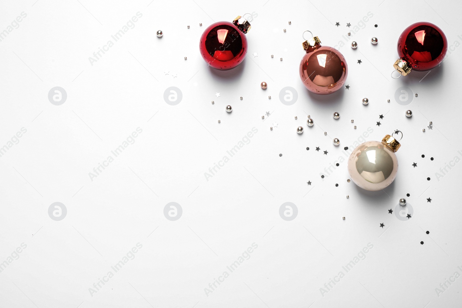 Photo of Colorful Christmas balls and sparkles on white background, top view. Space for text