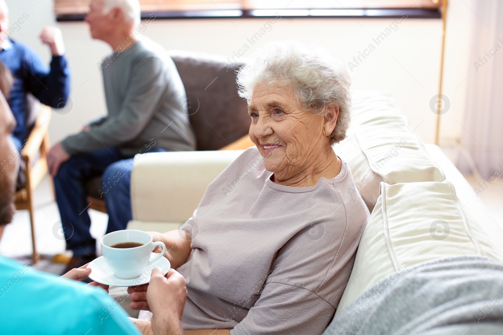 Photo of Medical worker taking care of elderly woman in geriatric hospice