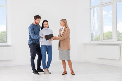 Photo of Real estate agent showing new apartment to couple