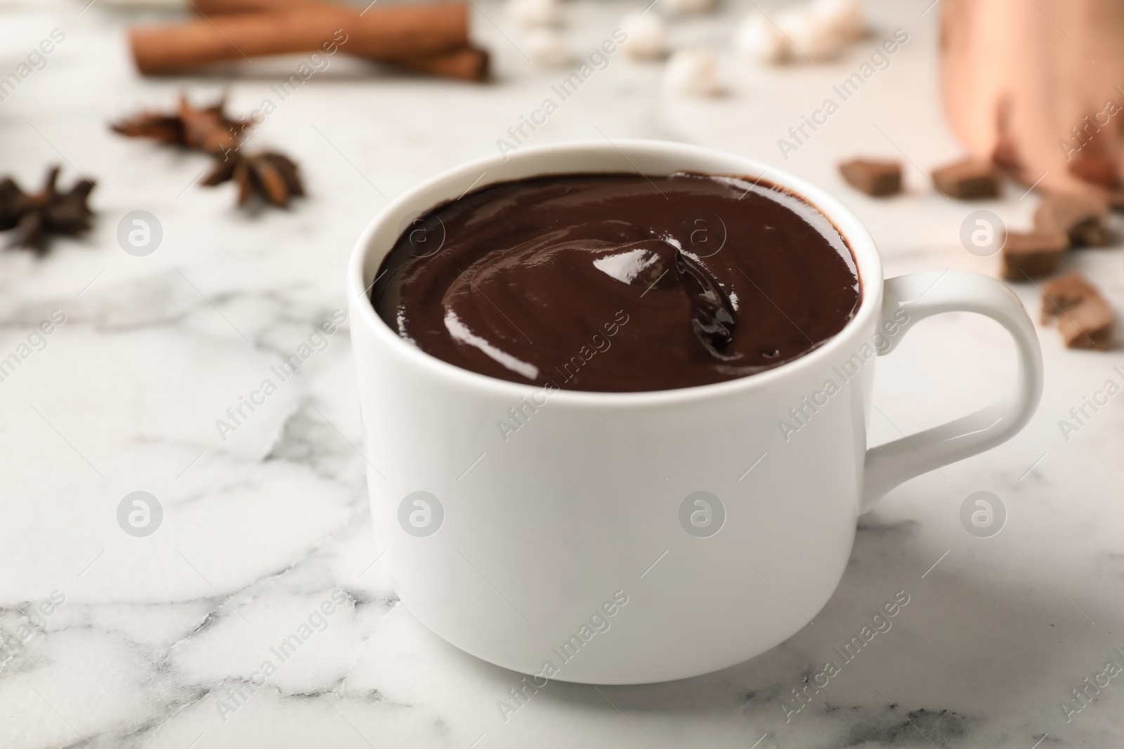 Photo of Cup of tasty chocolate drink on marble table