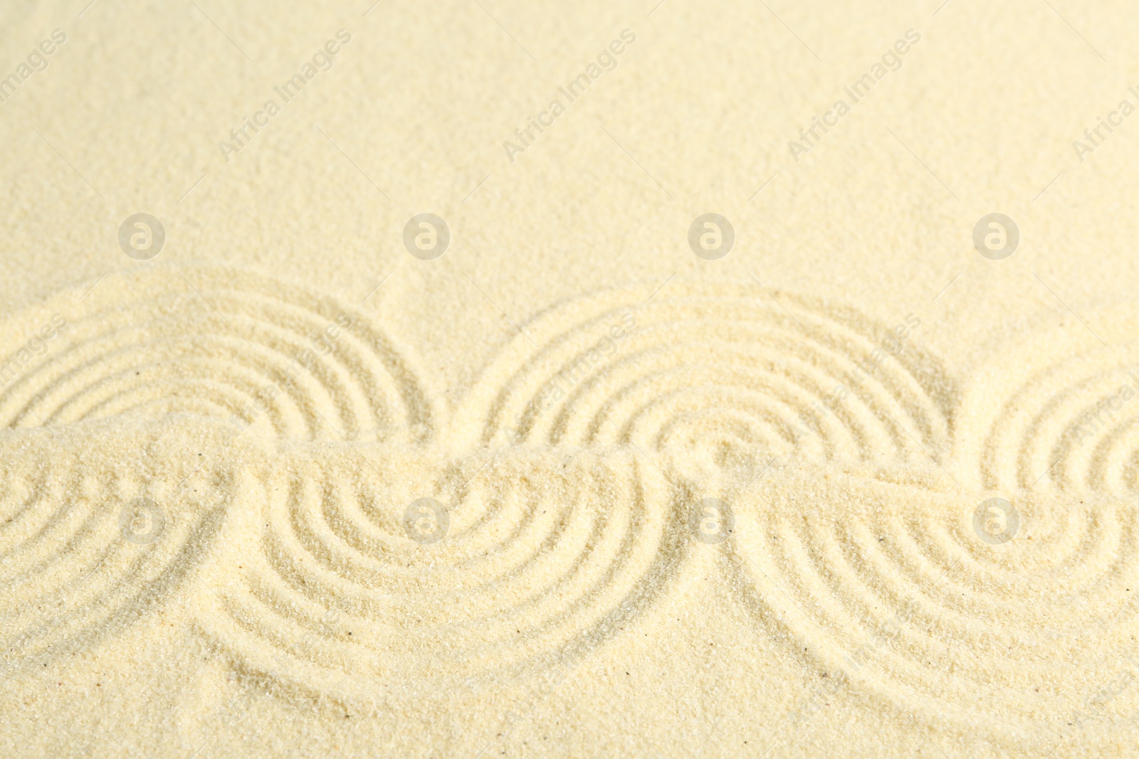 Photo of Zen rock garden. Wave pattern on beige sand