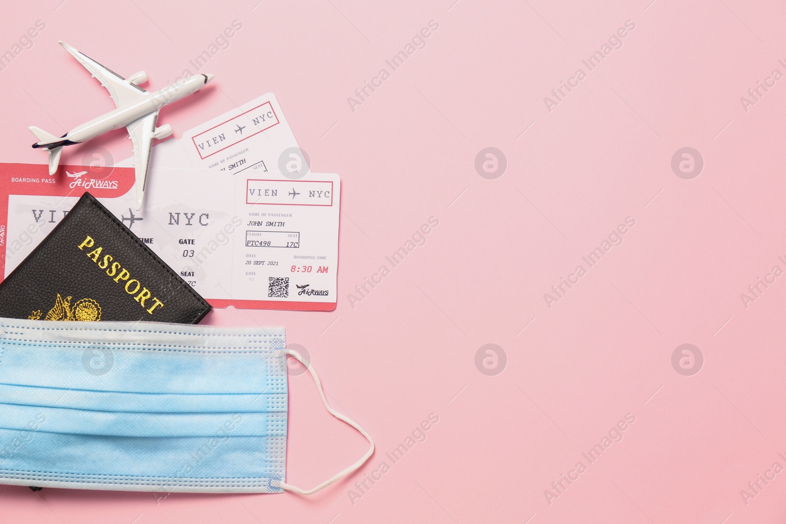 Photo of Flat lay composition with passport and protective mask on pink background, space for text. Travel during quarantine