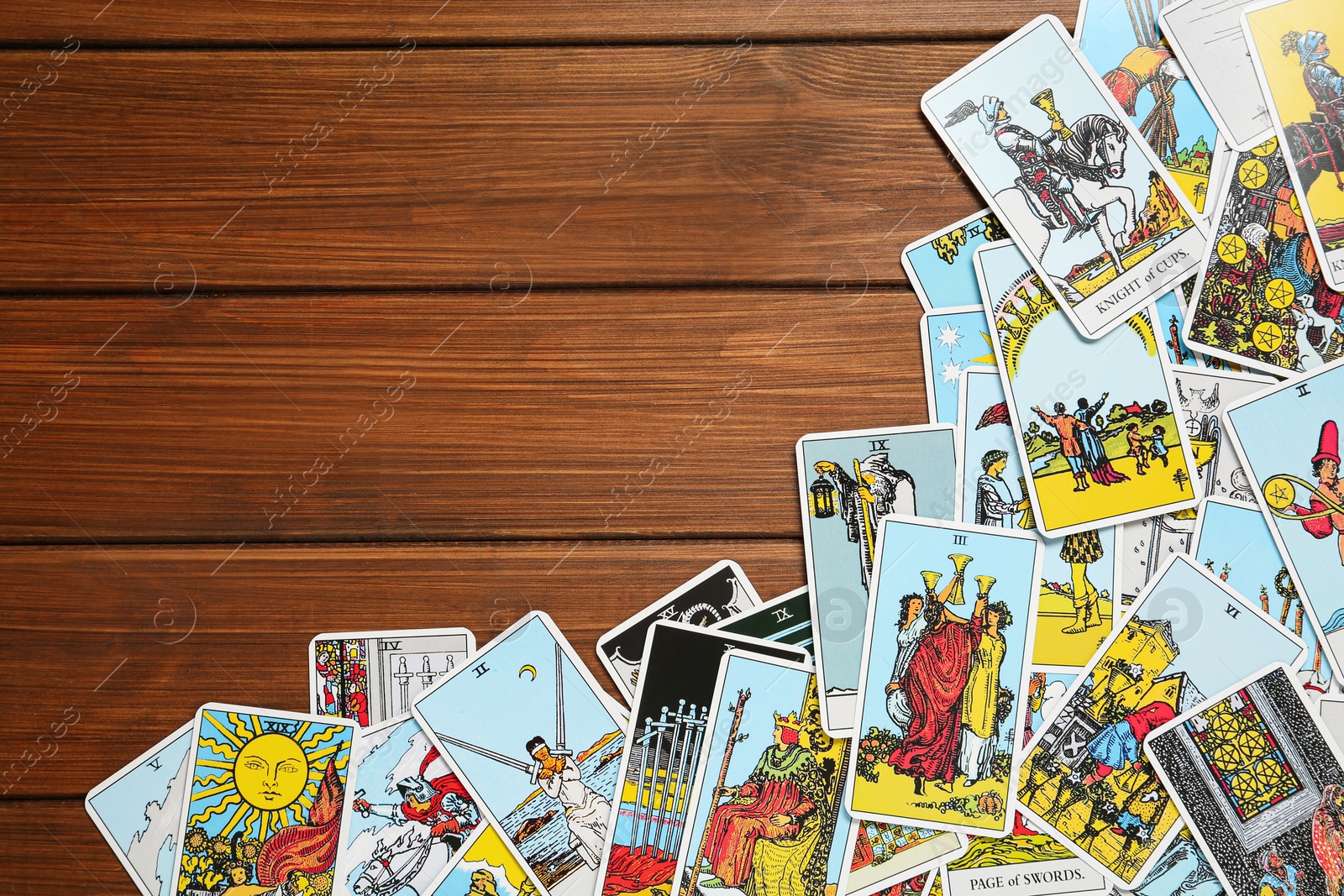 Photo of Tarot cards on wooden table, top view. Space for text