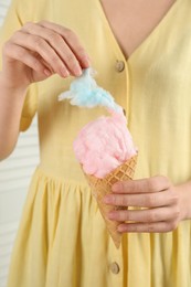 Photo of Woman with waffle cone eating cotton candy, closeup